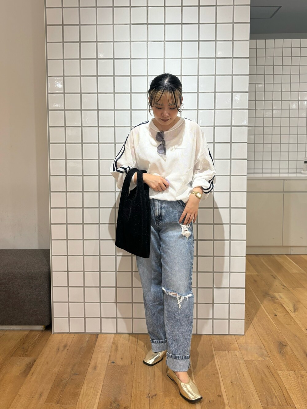 ブラック系のトートバッグ、ゴールド系のバレエシューズ、ホワイト系のタンクトップを着用したレディースの秋コーディネートの2枚目の写真