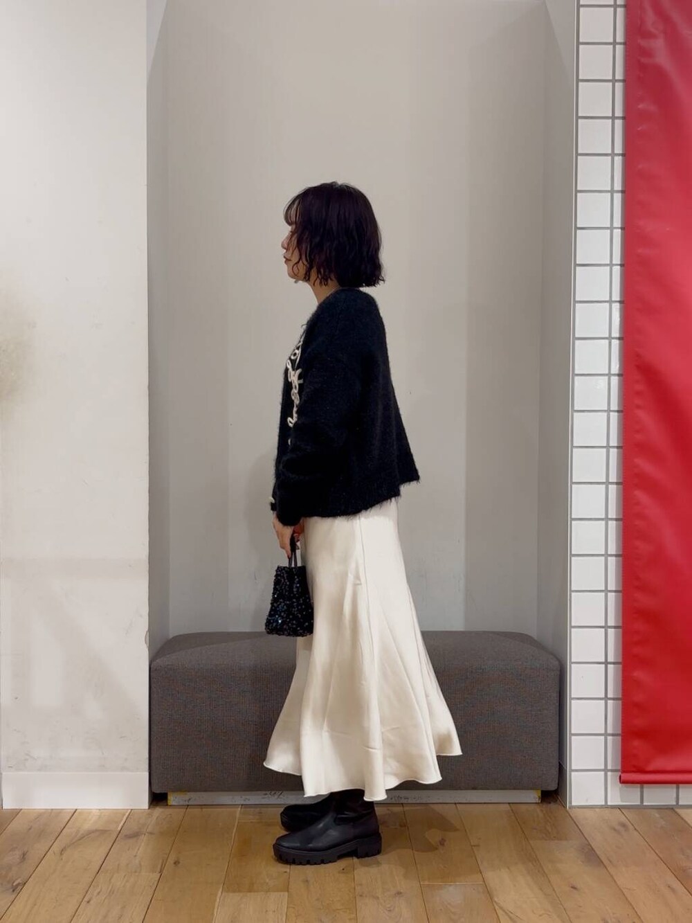 ブラック系のショルダーバッグ、ブラック系のブーツ、ブラック系のカーディガン/ボレロを着用したレディースの冬コーディネートの3枚目の写真