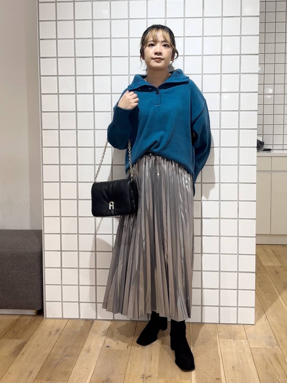 ブラック系のブーツ、ブラック系のショルダーバッグ、ブルー系のニット/セーターを着用したレディースの秋コーディネートの2枚目の写真