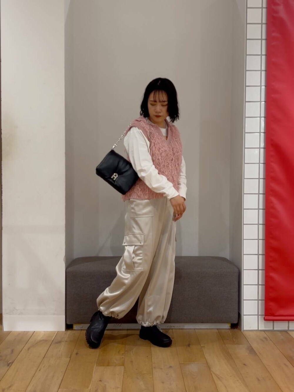 ブラック系のブーツ、その他のTシャツ/カットソー、ブラック系のショルダーバッグを着用したレディースの冬コーディネートの3枚目の写真