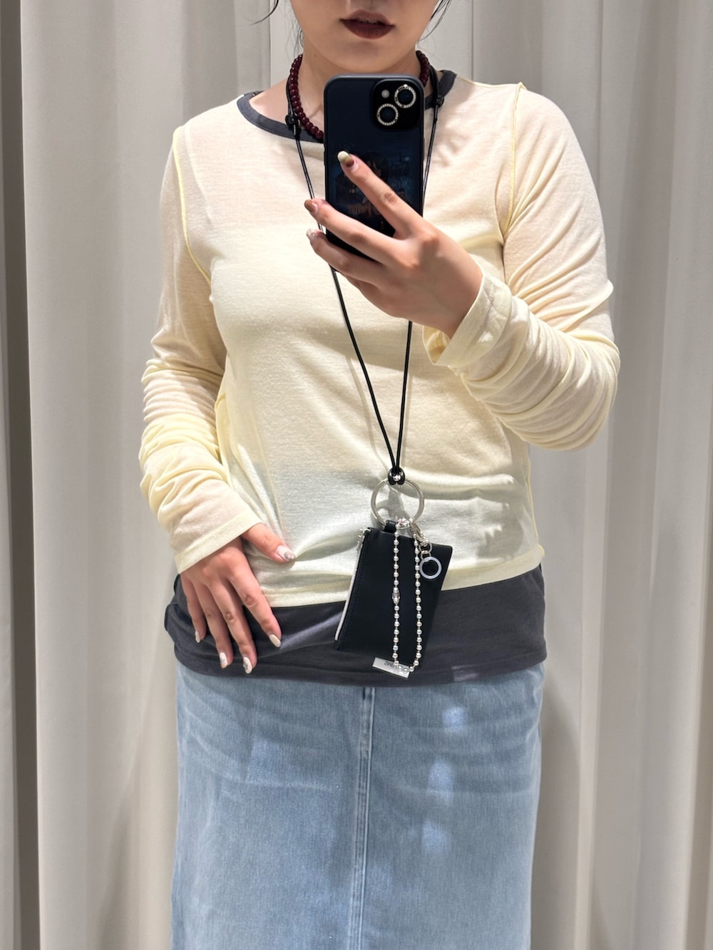 イエロー系のTシャツ/カットソー、ブルー系のスカート、ブラック系のブーツを着用したレディースの秋コーディネートの2枚目の写真