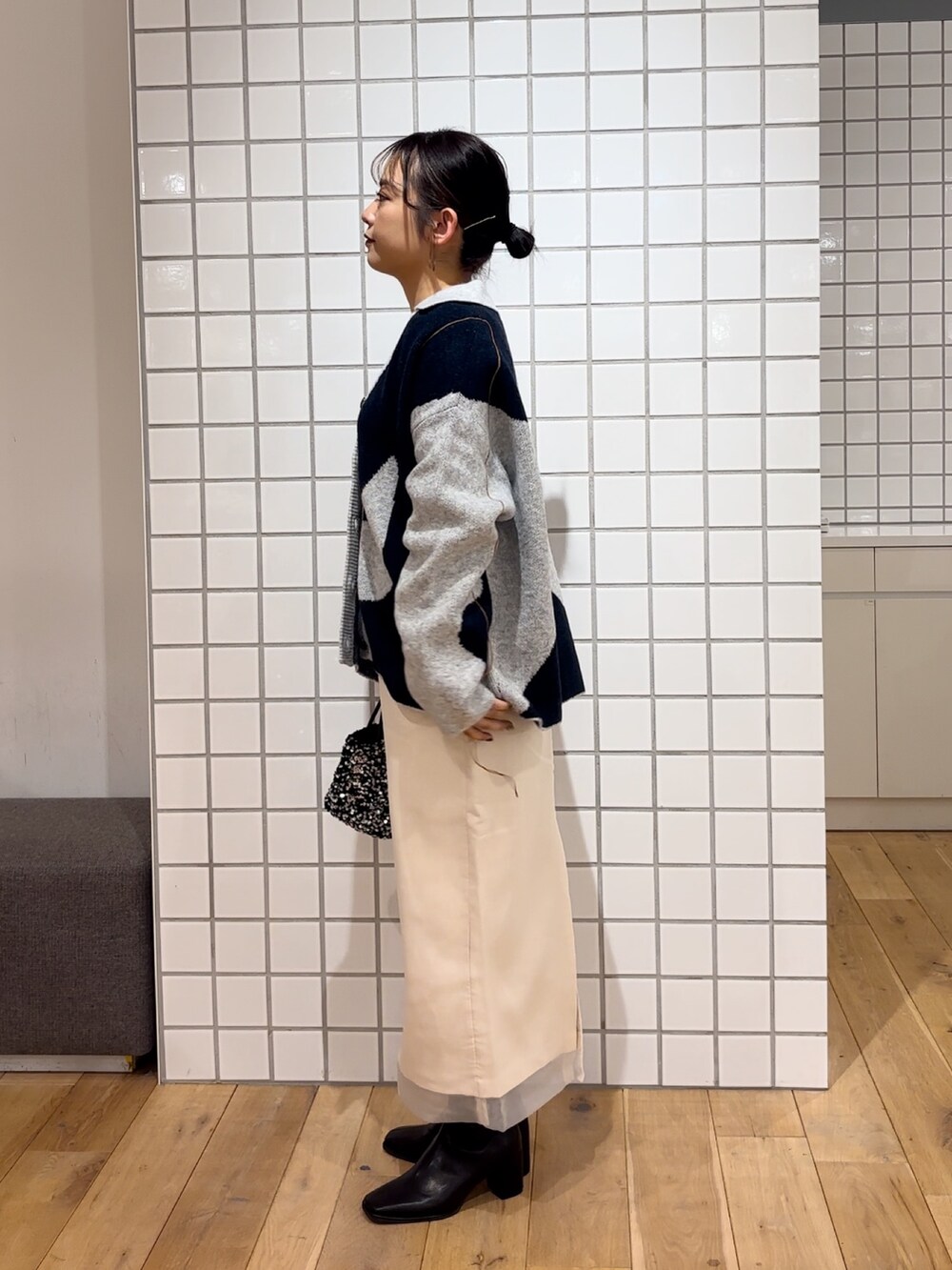 ホワイト系のカーディガン/ボレロ、ブルー系のニット/セーター、シルバー系のショルダーバッグを着用したレディースの冬コーディネートの3枚目の写真