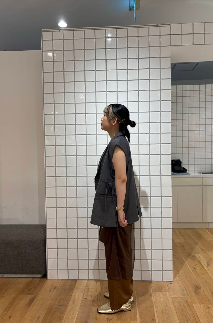ゴールド系のバレエシューズ、ブラウン系のその他パンツ、グレー系のベストを着用したレディースの秋コーディネートの3枚目の写真