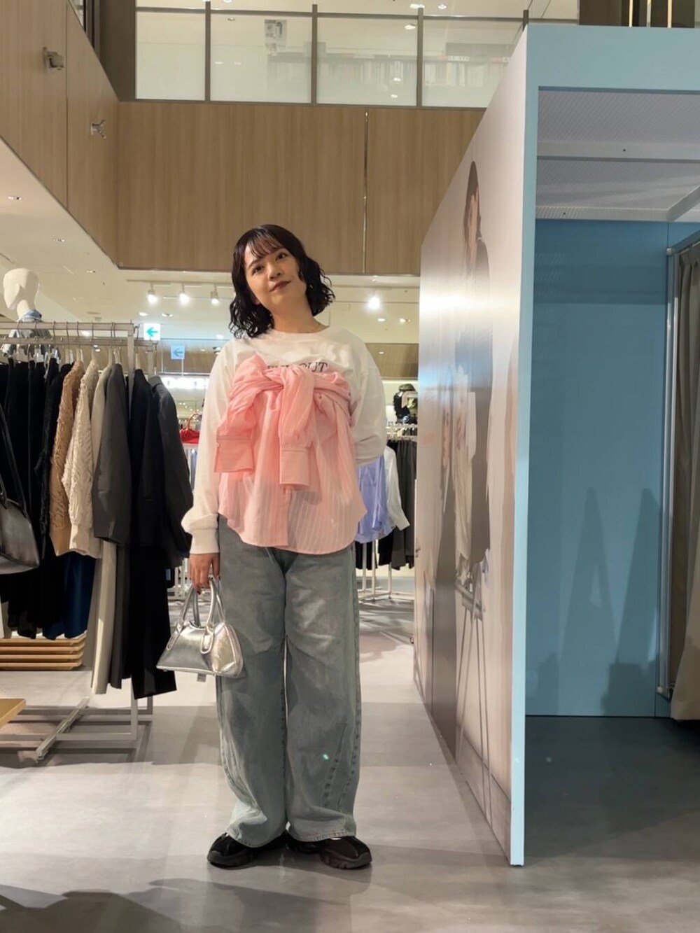 ブラック系のスニーカー、シルバー系のボストンバッグ、その他のTシャツ/カットソーを着用したレディースの春コーディネートの3枚目の写真