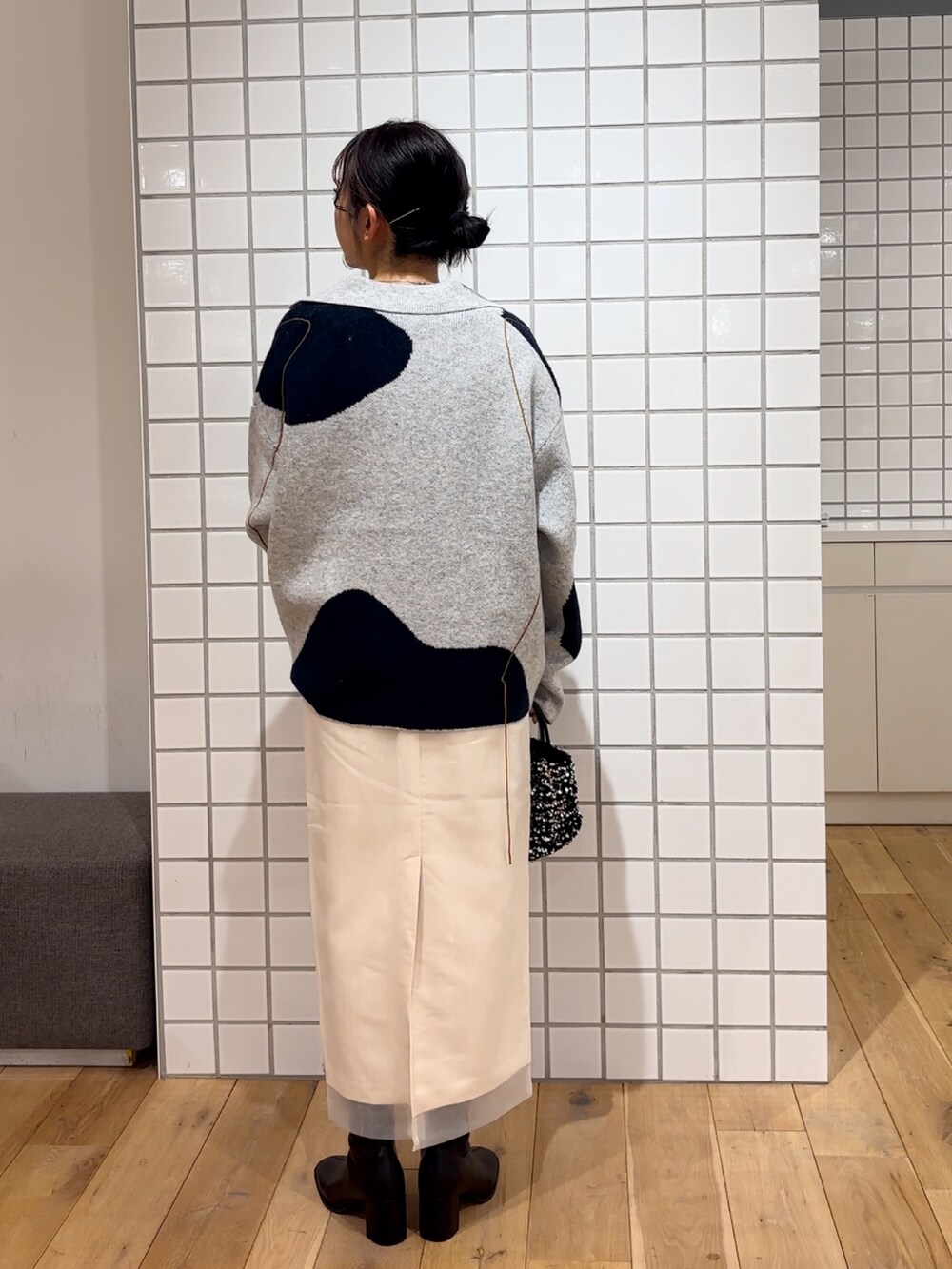 ホワイト系のカーディガン/ボレロ、ブルー系のニット/セーター、シルバー系のショルダーバッグを着用したレディースの冬コーディネートの4枚目の写真