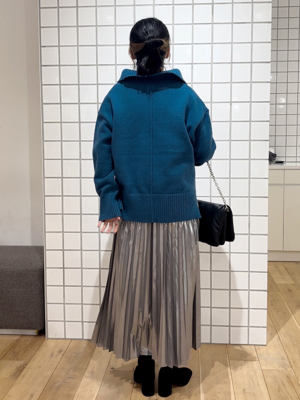 ブルー系のニット/セーター、シルバー系のスカート、ブラック系のショルダーバッグを着用したレディースの秋コーディネートの5枚目の写真