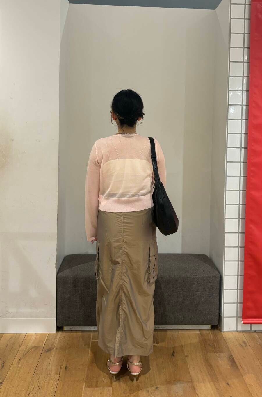 ゴールド系のサンダル、ブラック系のショルダーバッグ、ホワイト系のキャミソールを着用したレディースの夏コーディネートの4枚目の写真