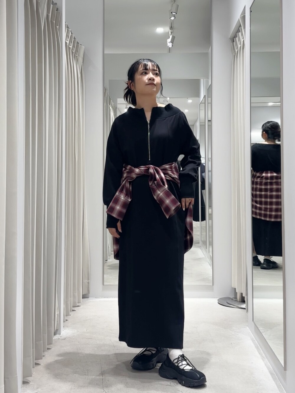 ブラック系のワンピース、レッド系のシャツ/ブラウス、ブラック系のスニーカーを着用したレディースの秋コーディネートの2枚目の写真