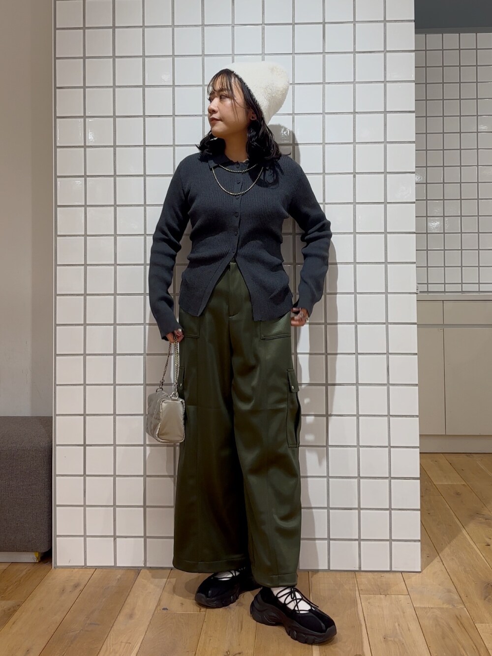 グレー系のカーディガン/ボレロ、ブラック系のスニーカー、シルバー系のショルダーバッグを着用したレディースの冬コーディネートの2枚目の写真