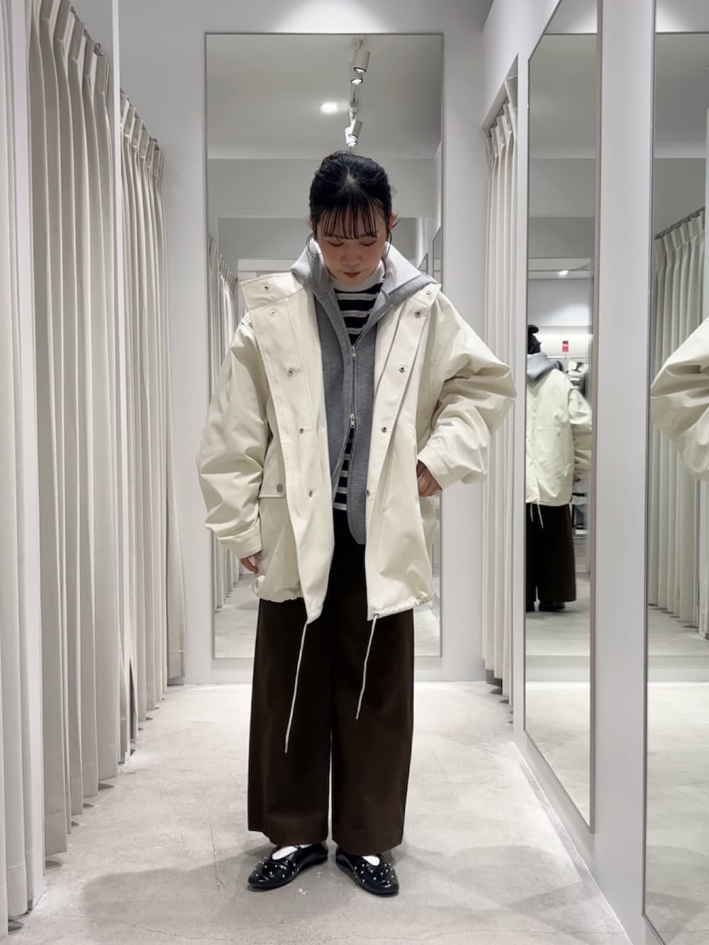 ホワイト系のミリタリージャケット、グレー系のパーカー、ブルー系のTシャツ/カットソーを着用したレディースの冬コーディネートの4枚目の写真