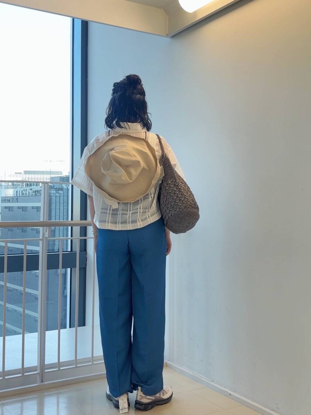 グレー系のハンドバッグ、ホワイト系のスニーカー、ブルー系のその他パンツを着用したレディースの春コーディネートの7枚目の写真