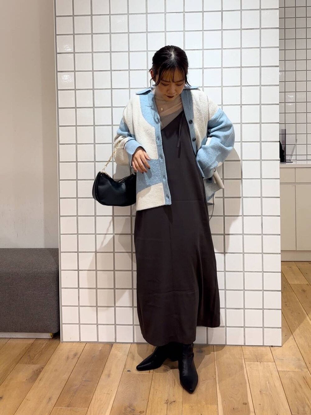 ベージュ系のTシャツ/カットソー、ブラック系のショルダーバッグ、ブラック系のブーツを着用したレディースの冬コーディネートの4枚目の写真