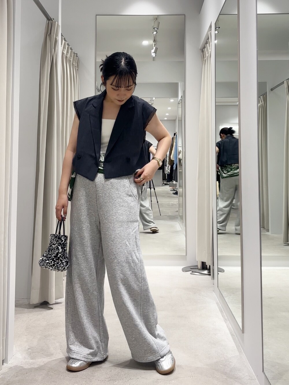 グレー系のベスト、グレー系のその他パンツ、シルバー系のショルダーバッグを着用したレディースの秋コーディネートの4枚目の写真