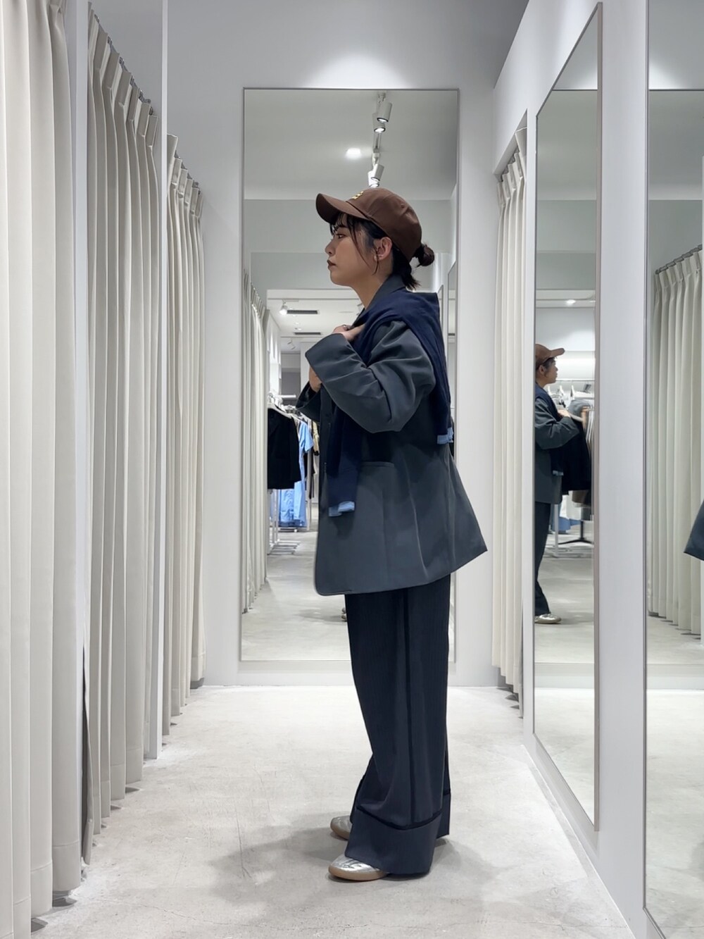 グレー系のその他パンツ、グレー系のその他アウター、ブルー系のニット/セーターを着用したレディースの秋コーディネートの2枚目の写真