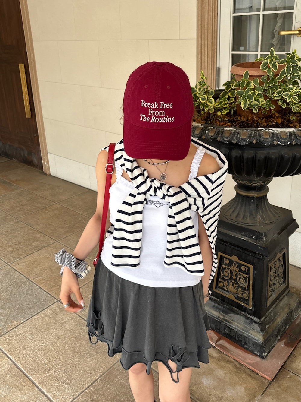 ブラック系のスニーカー、グレー系のスカート、ホワイト系のTシャツ/カットソーを着用したレディースの夏コーディネートの2枚目の写真