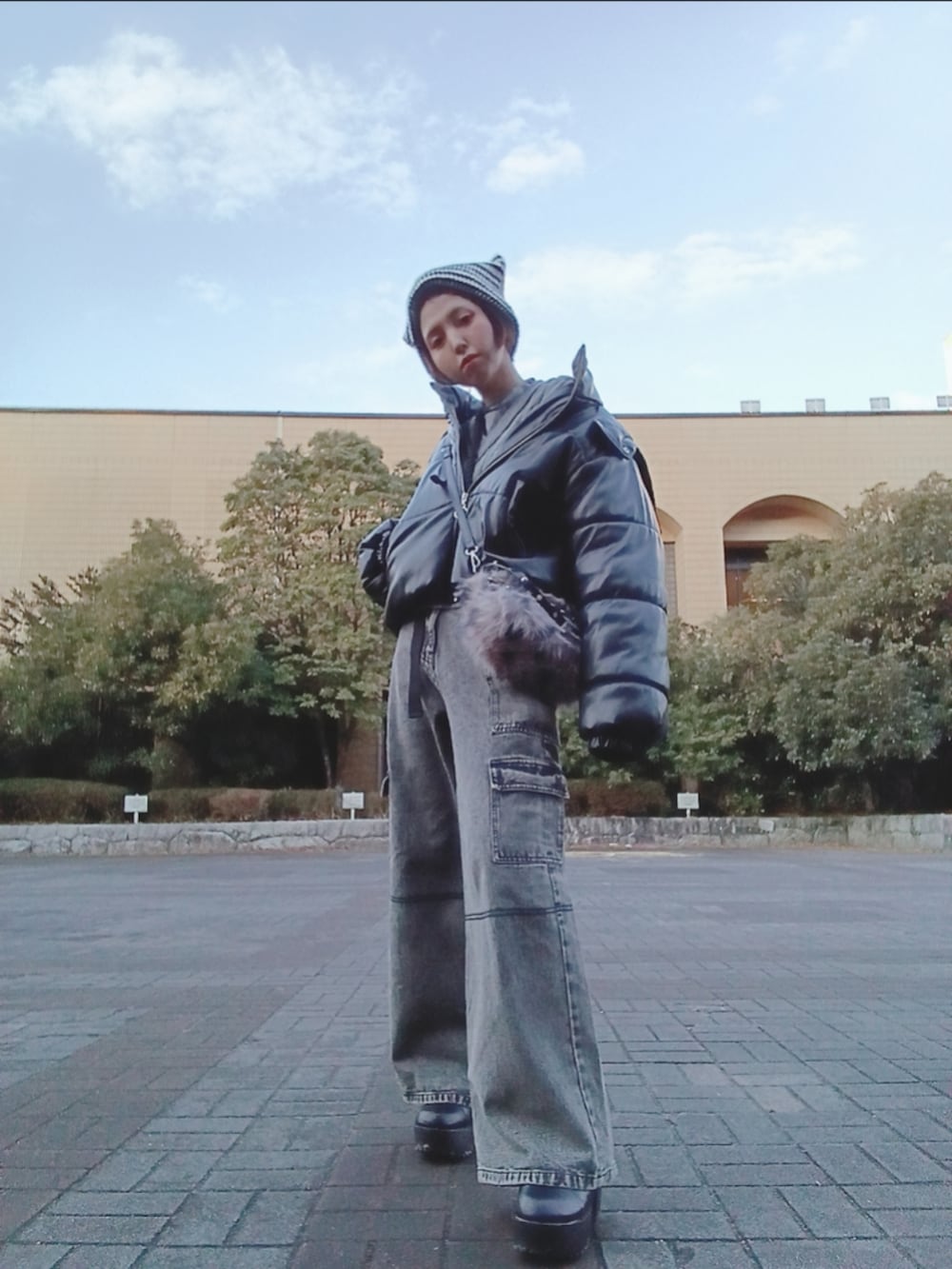 グレー系のニット/セーター、ブラック系のブーツ、グレー系のデニムパンツを着用したレディースの冬コーディネートの2枚目の写真