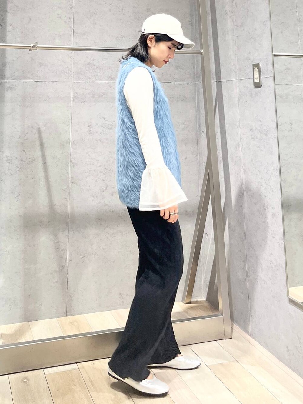 シルバー系のパンプス、ホワイト系のTシャツ/カットソー、ブルー系のベストを着用したレディースの秋コーディネートの4枚目の写真