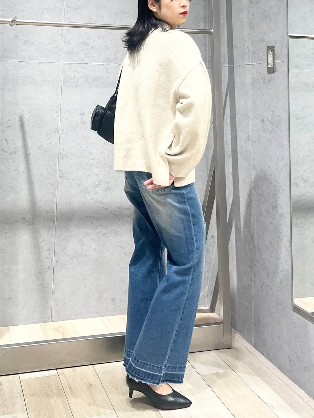 ブラック系のパンプス、ブラック系のショルダーバッグ、ベージュ系のニット/セーターを着用したレディースの冬コーディネートの3枚目の写真