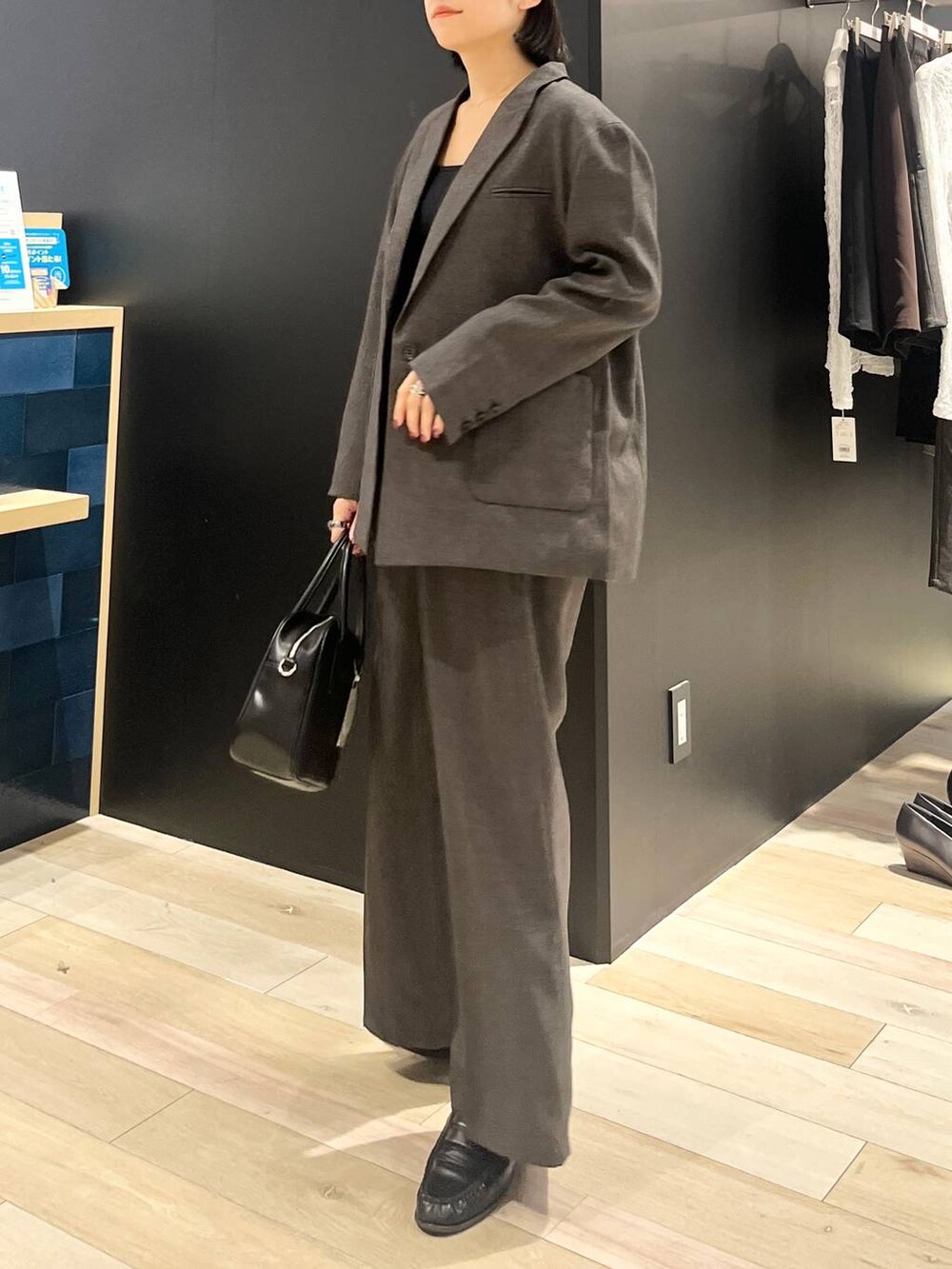 ブラック系のボストンバッグ、グレー系のその他パンツ、グレー系のテーラードジャケットを着用したレディースの秋コーディネートの3枚目の写真