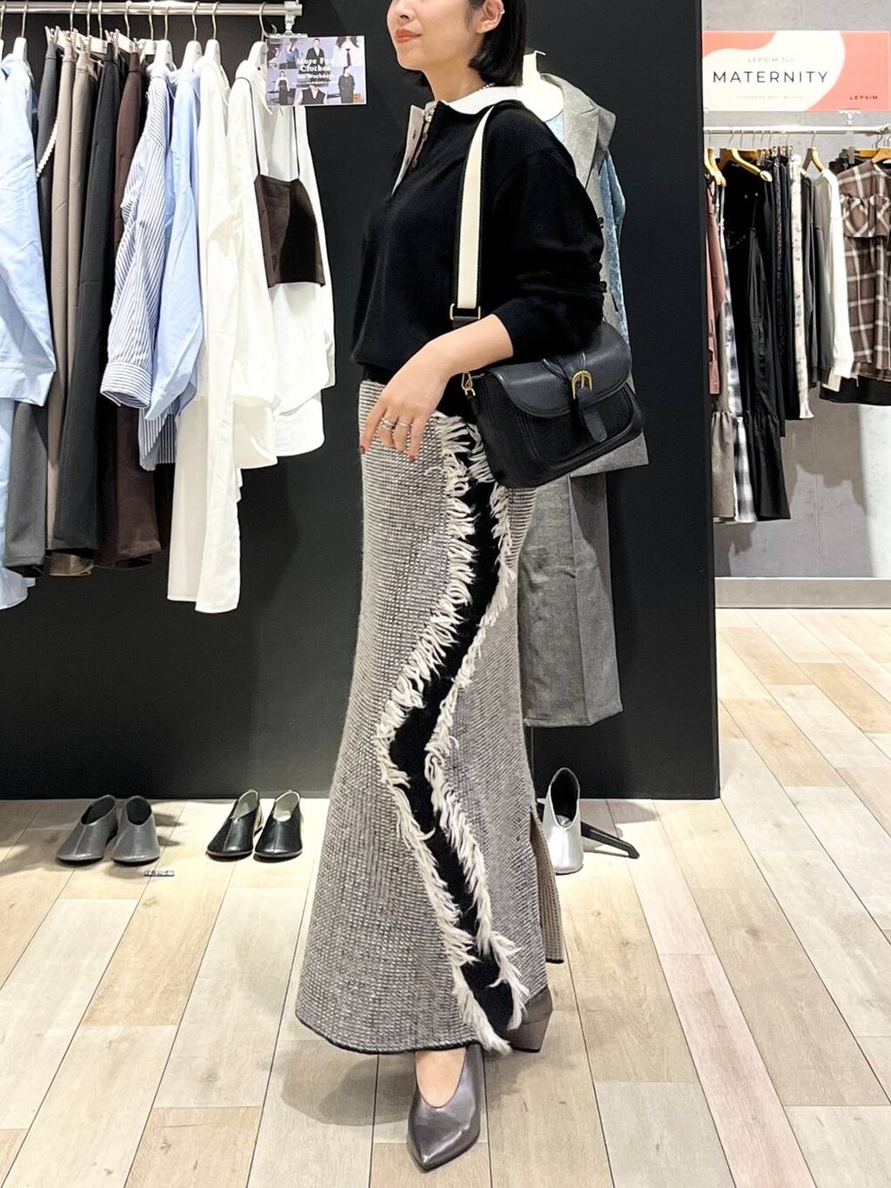 ブラック系のショルダーバッグ、ブラック系のニット/セーター、その他のパンプスを着用したレディースの秋コーディネートの2枚目の写真