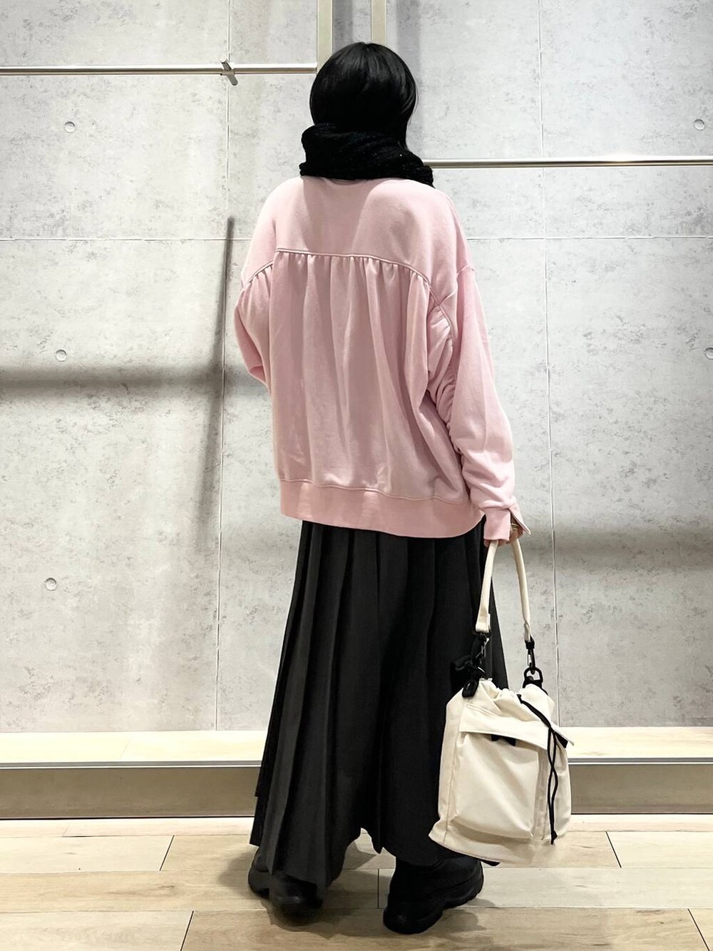 ホワイト系のショルダーバッグ、ピンク系のスウェット、ブラック系のブーツを着用したレディースの秋コーディネートの7枚目の写真