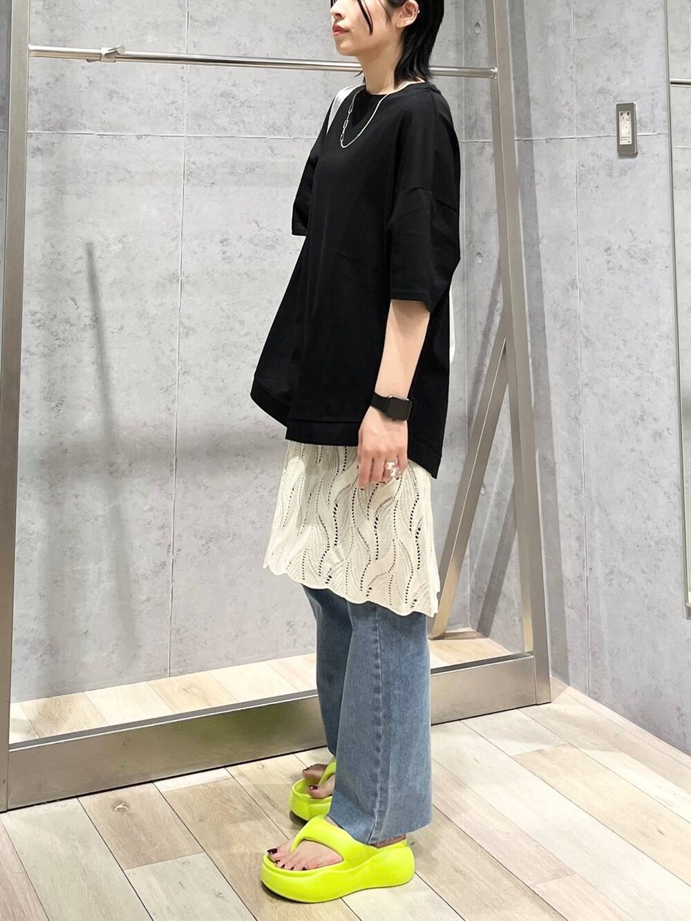 イエロー系のサンダル、グレー系のショルダーバッグ、ブルー系のデニムパンツを着用したレディースの春コーディネートの3枚目の写真