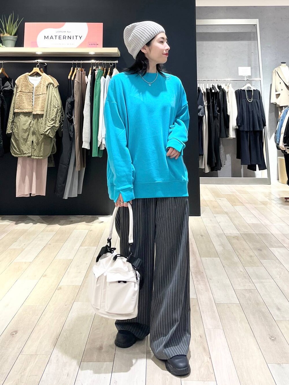 ホワイト系のショルダーバッグ、グレー系のその他パンツ、ブラック系のスニーカーを着用したレディースの冬コーディネートの4枚目の写真