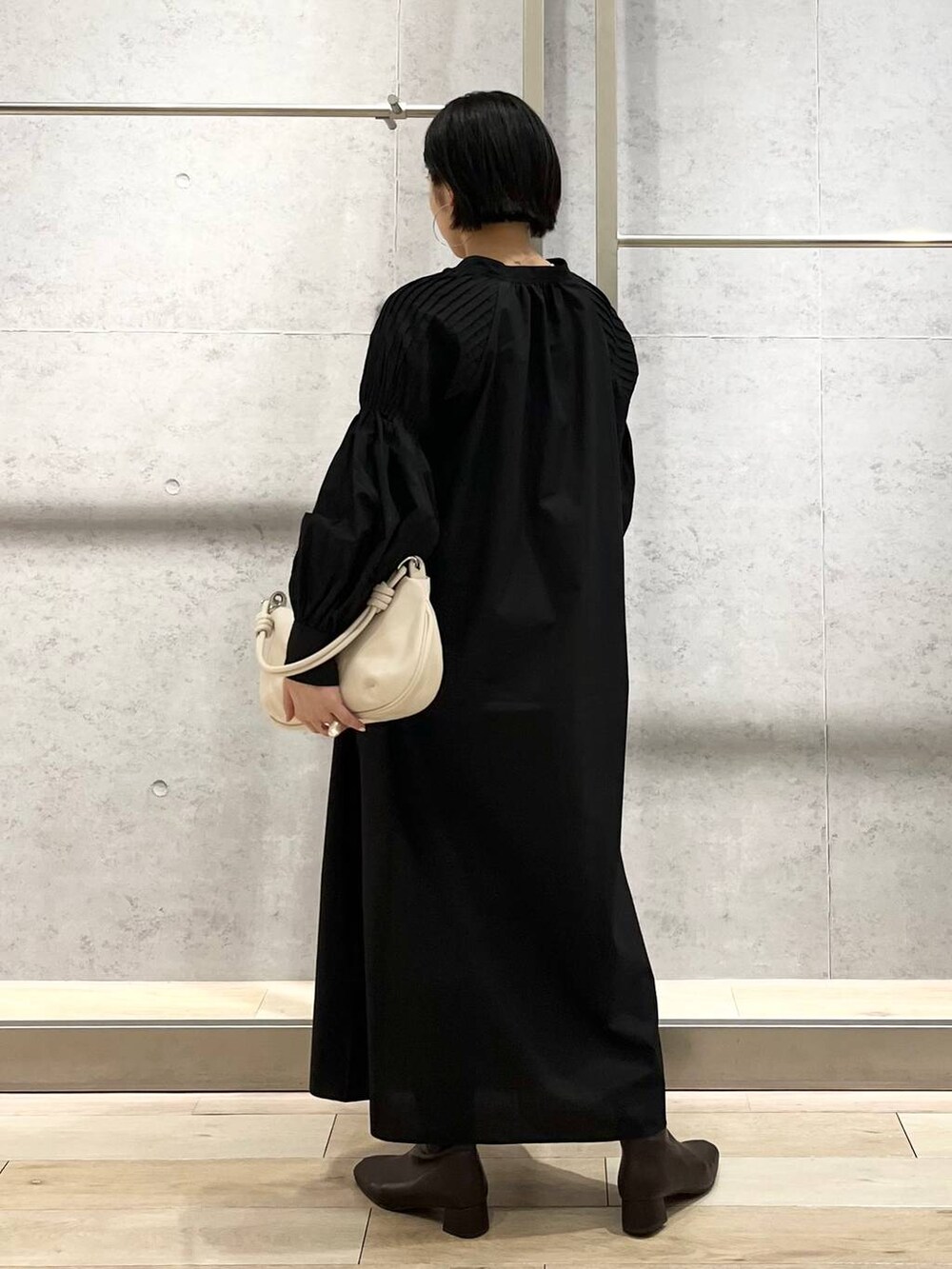 ホワイト系のキャミソール、ブラック系のワンピース、ホワイト系のショルダーバッグを着用したレディースの秋コーディネートの5枚目の写真