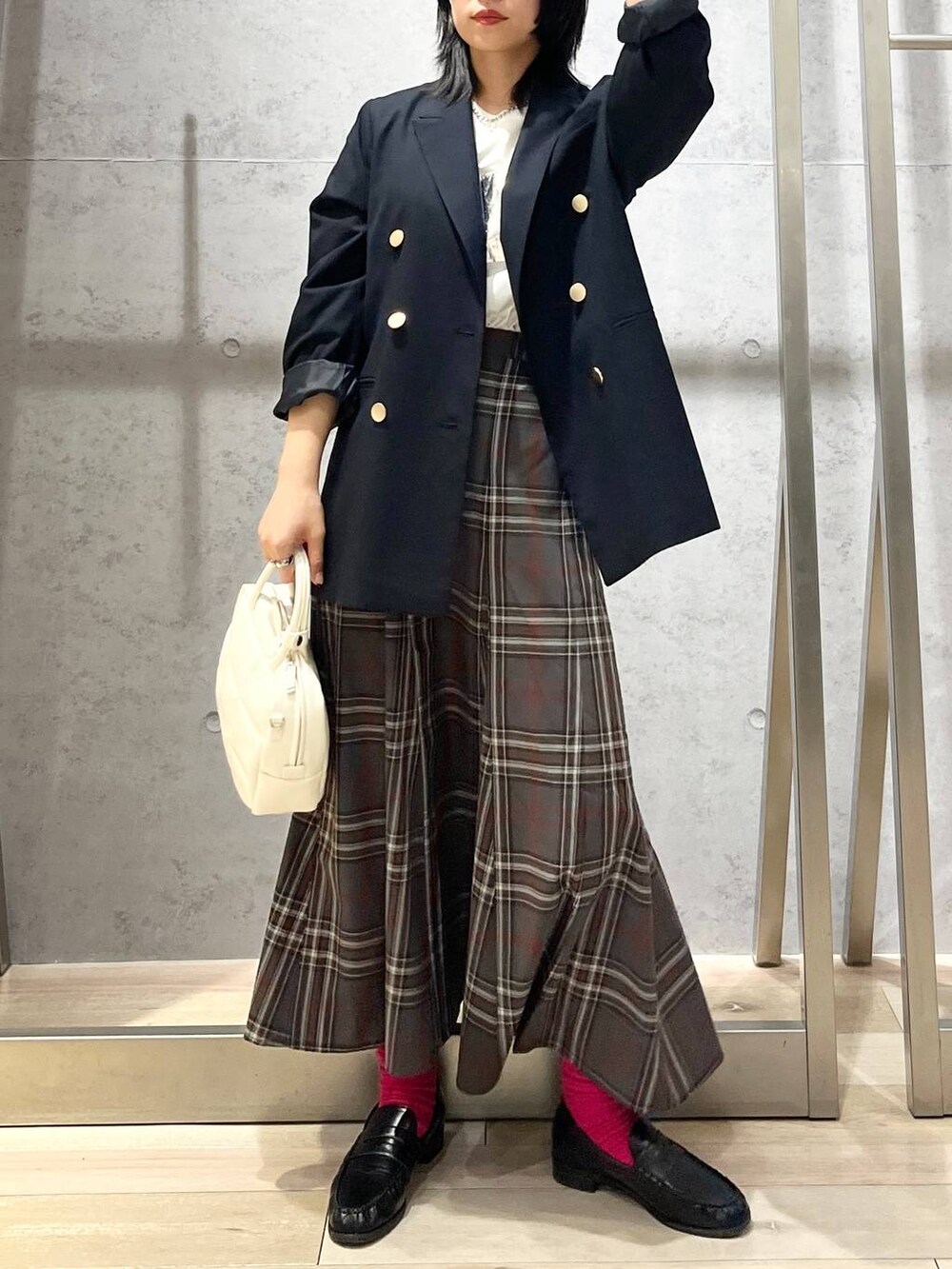 ブルー系のテーラードジャケット、ホワイト系のボストンバッグ、ブラック系のローファーを着用したレディースの秋コーディネートの5枚目の写真