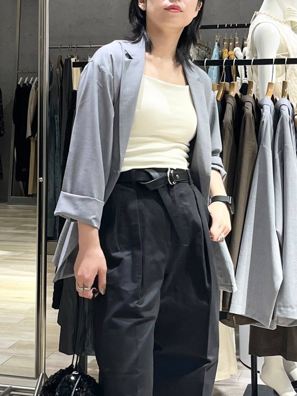 グレー系のチノパンツ、ブラック系のスニーカー、ホワイト系のキャミソールを着用したレディースの秋コーディネートの3枚目の写真