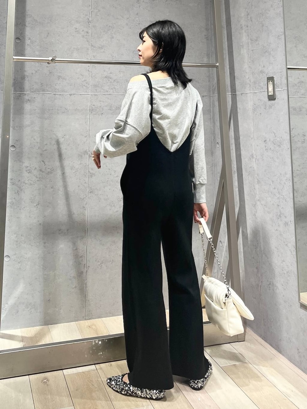 ホワイト系のショルダーバッグ、シルバー系のパンプス、グレー系のスウェットを着用したレディースの秋コーディネートの3枚目の写真