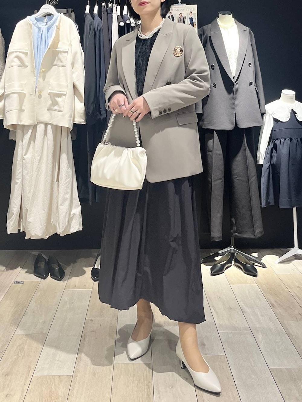 ブラウン系のテーラードジャケット、ブラック系のスカート、ブラック系のシャツ/ブラウスを着用したレディースの冬コーディネートの2枚目の写真