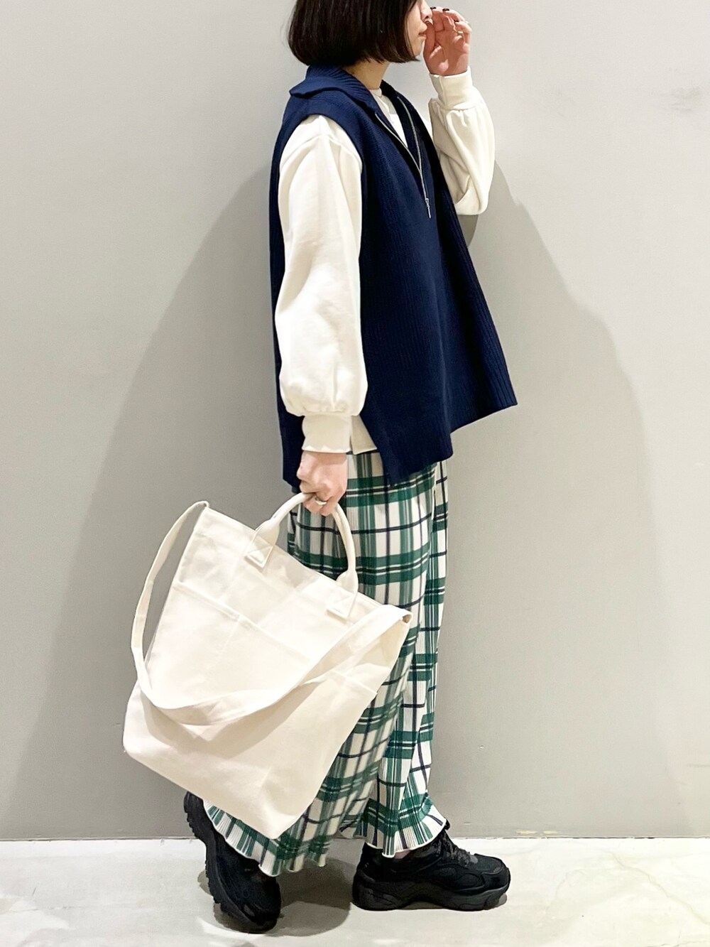 ブラック系のスニーカー、ホワイト系のスウェット、ホワイト系のショルダーバッグを着用したレディースの冬コーディネートの4枚目の写真