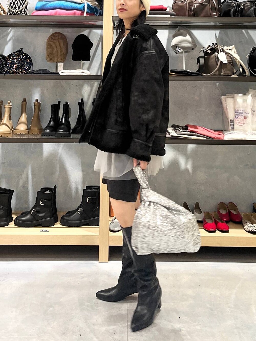 グレー系のニット/セーター、ブラック系のその他アウター、ホワイト系のTシャツ/カットソーを着用したレディースの秋コーディネートの3枚目の写真