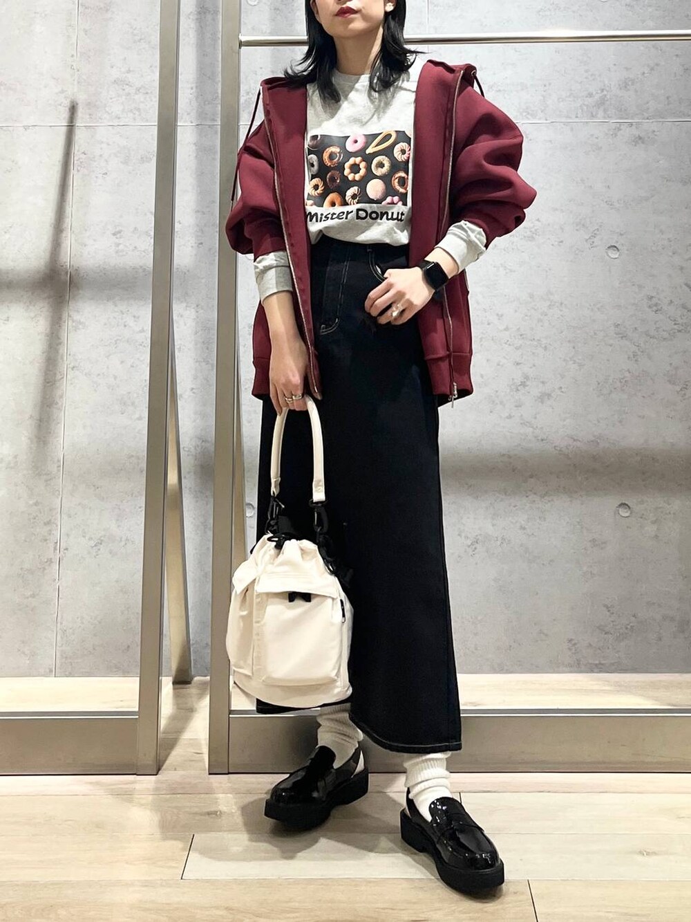 ホワイト系のショルダーバッグ、レッド系のパーカー、ブラック系のデニムスカートを着用したレディースの冬コーディネートの8枚目の写真