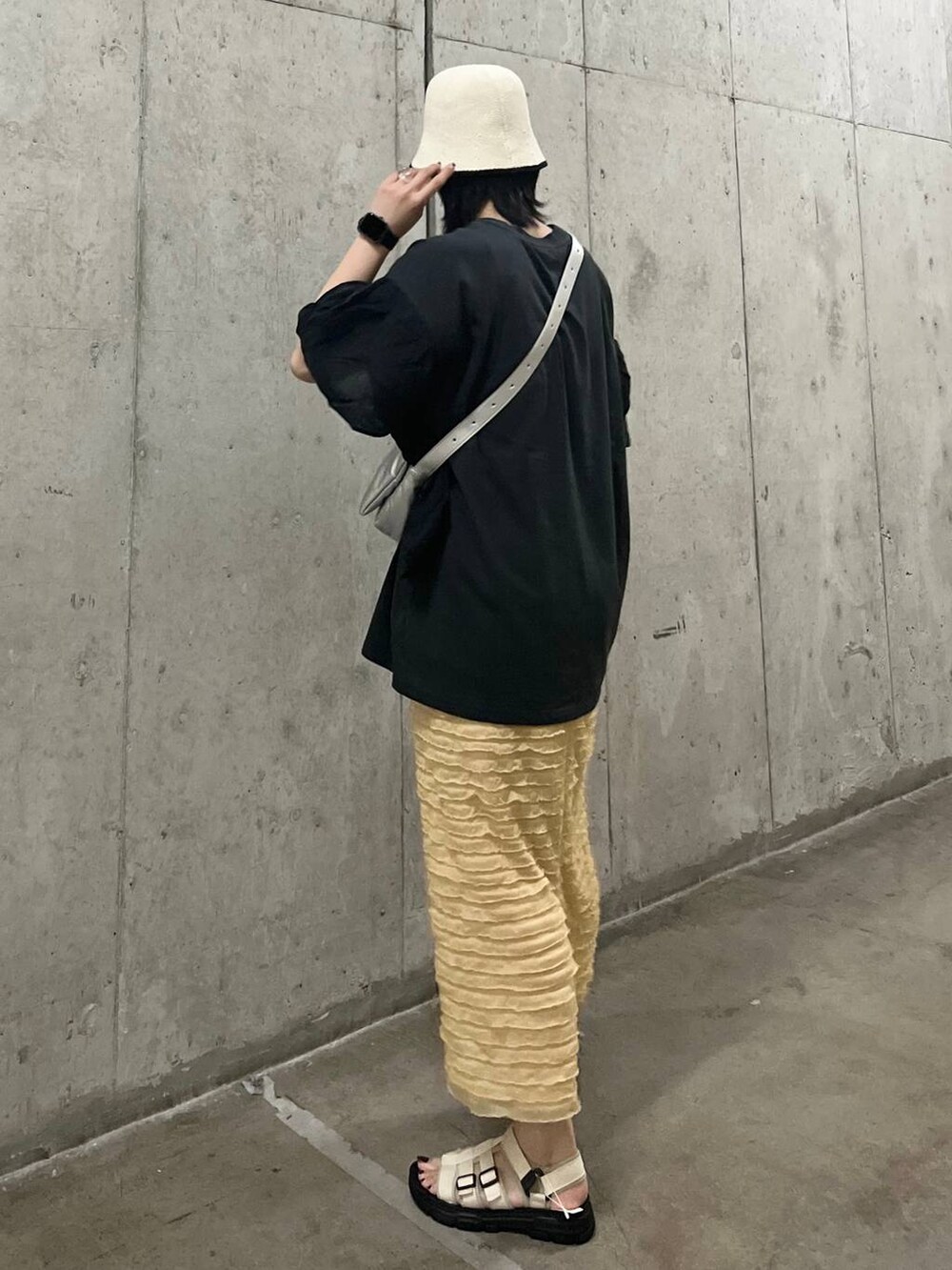 ベージュ系のスカート、シルバー系のショルダーバッグ、ホワイト系のサンダルを着用したレディースの春コーディネートの3枚目の写真