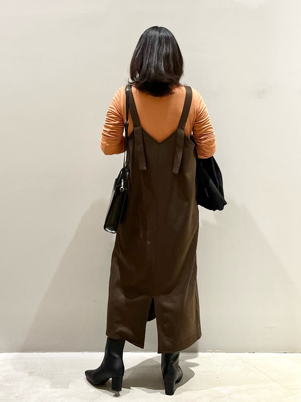 ブラウン系のワンピース、ブラック系のブーツ、ブラウン系のジャケット/アウターを着用したレディースの冬コーディネートの4枚目の写真