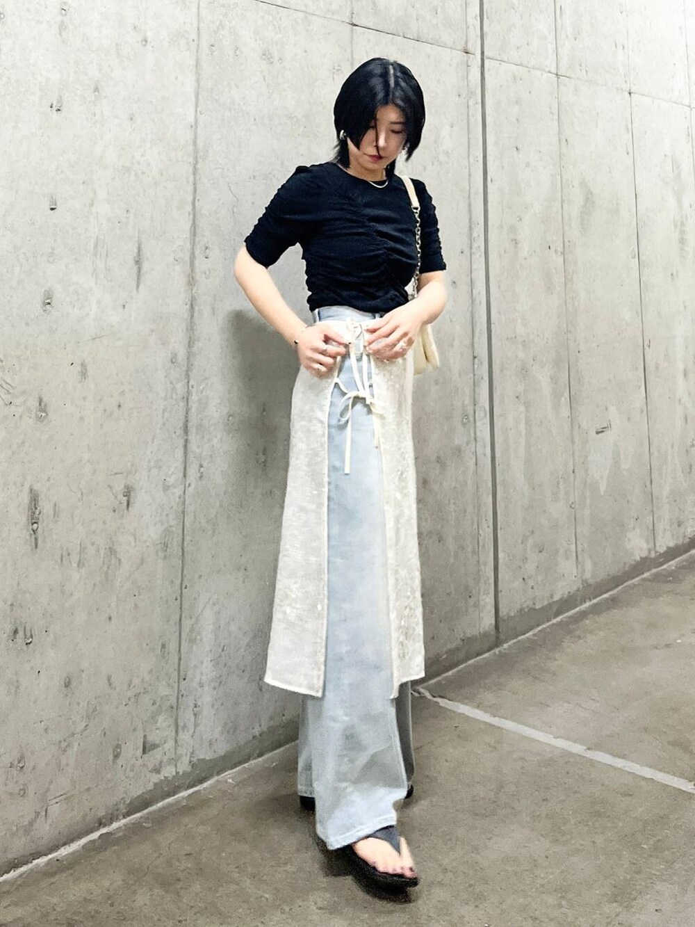 ホワイト系のショルダーバッグ、ブルー系のデニムパンツ、ブラック系のTシャツ/カットソーを着用したレディースの春コーディネートの2枚目の写真