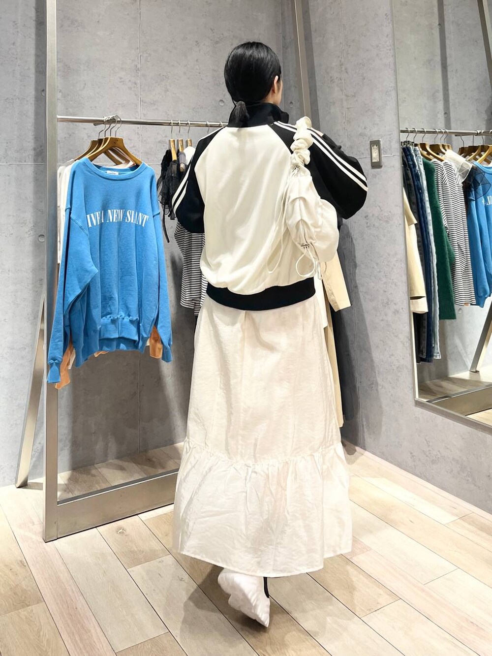 ホワイト系のスカート、ブラック系のブーツ、ブルー系のTシャツ/カットソーを着用したレディースの冬コーディネートの6枚目の写真