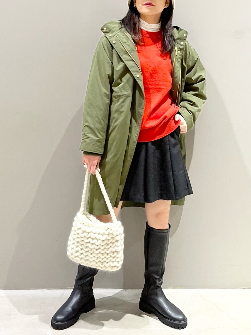 ブラック系のパンツ、ブラック系のブーツ、ホワイト系のバッグを着用したレディースの秋コーディネートの5枚目の写真