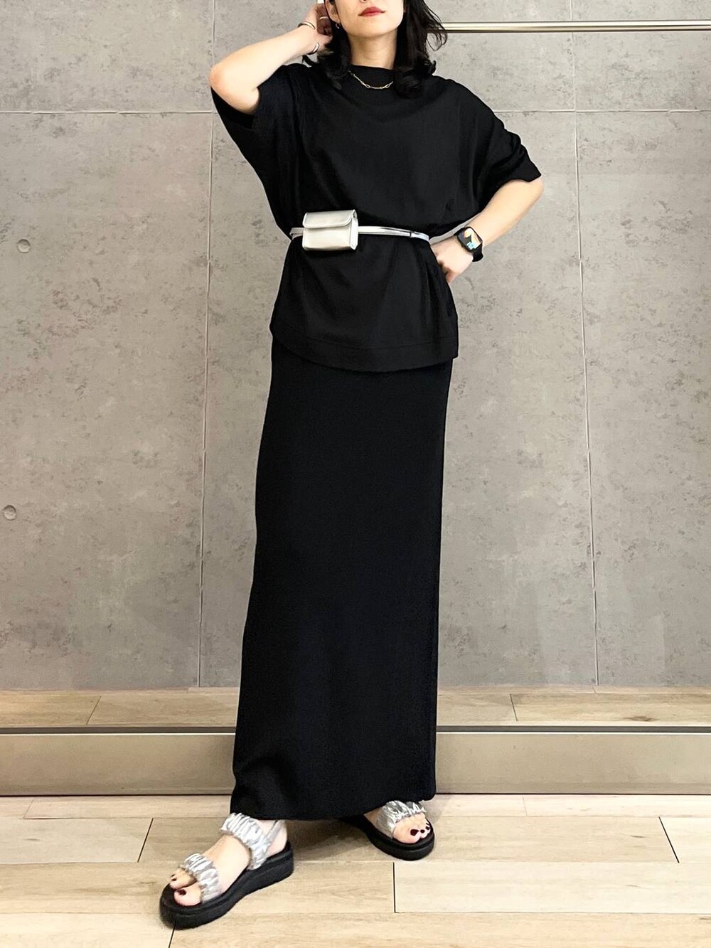 ブラック系のスカート、ブラック系のTシャツ/カットソー、シルバー系のサンダルを着用したレディースの春コーディネートの6枚目の写真