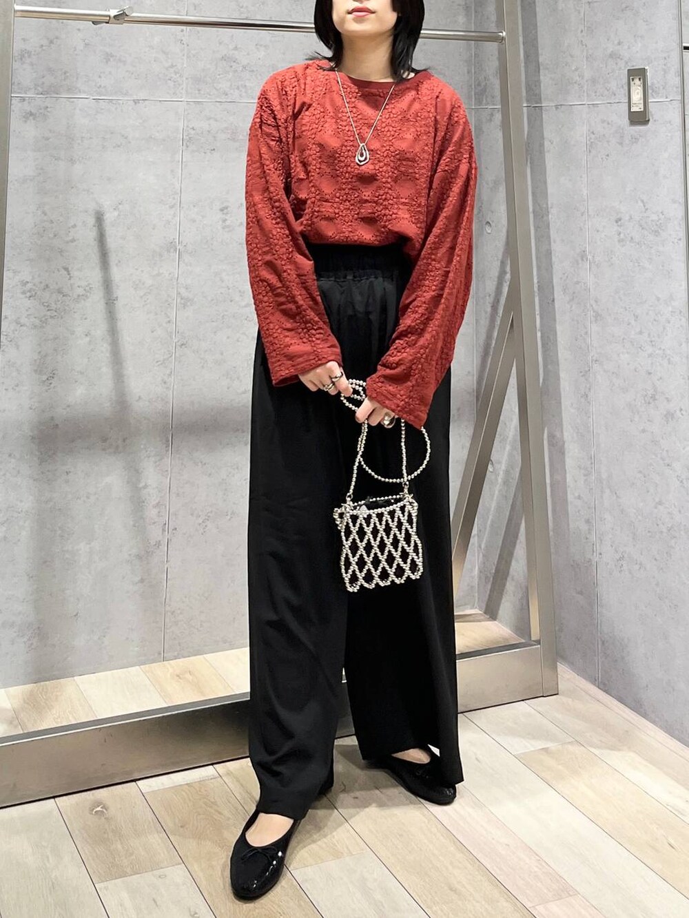 レッド系のTシャツ/カットソー、ブラック系のスラックス、シルバー系のショルダーバッグを着用したレディースの夏コーディネートの8枚目の写真