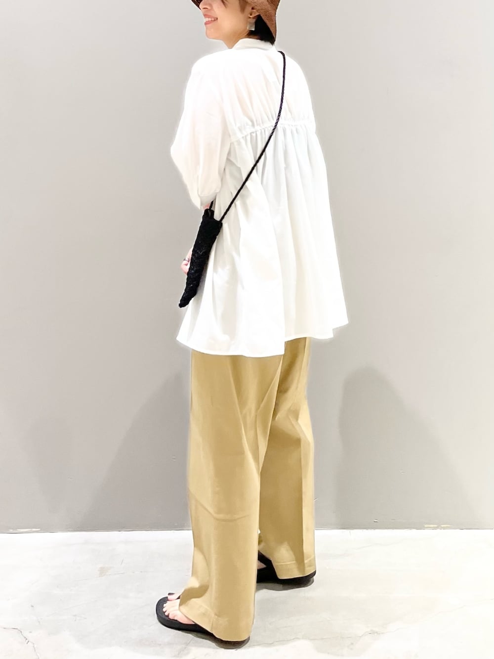ブラック系のサンダル、ベージュ系のチノパンツ、ブラック系のショルダーバッグを着用したレディースの夏コーディネートの6枚目の写真