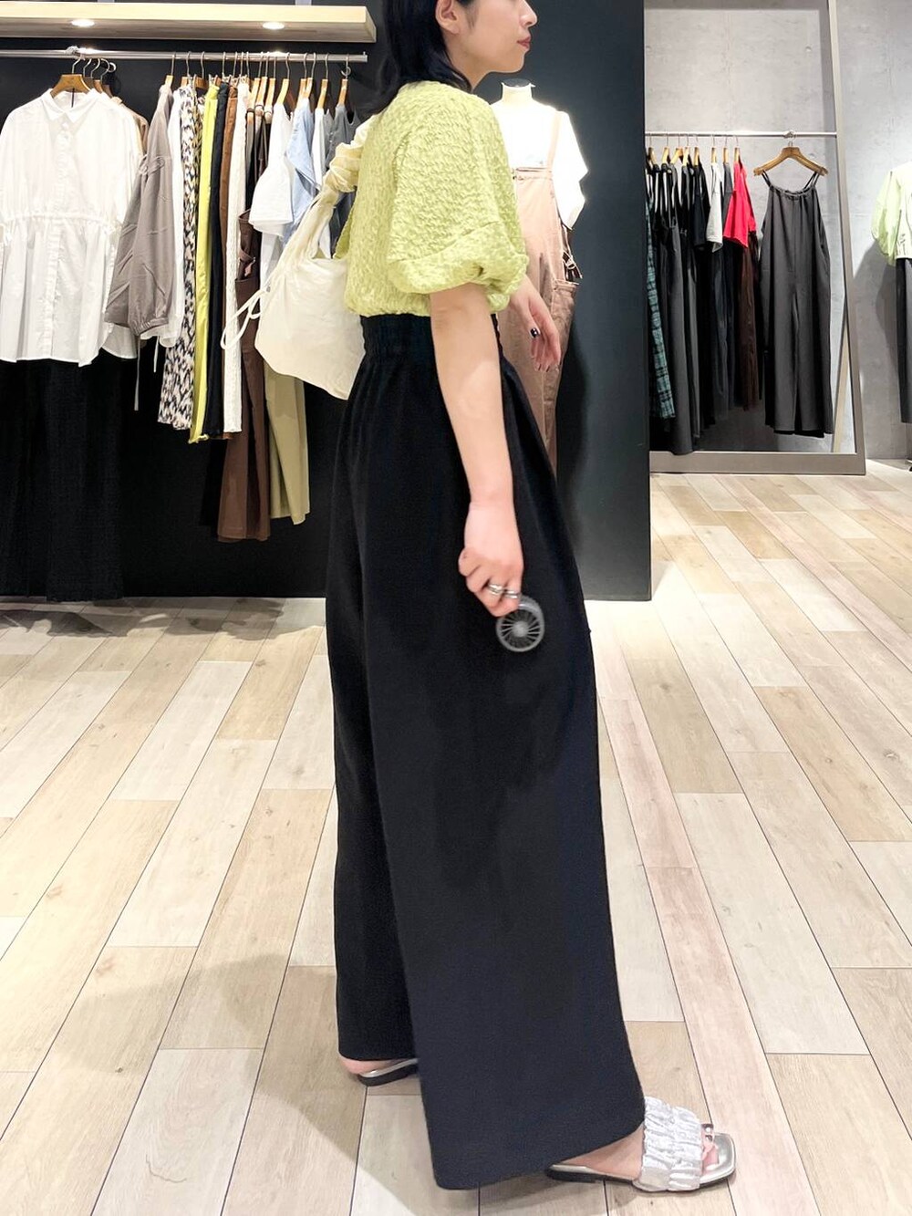 ブラック系のその他パンツ、グリーン系のTシャツ/カットソー、ホワイト系のショルダーバッグを着用したレディースの夏コーディネートの5枚目の写真