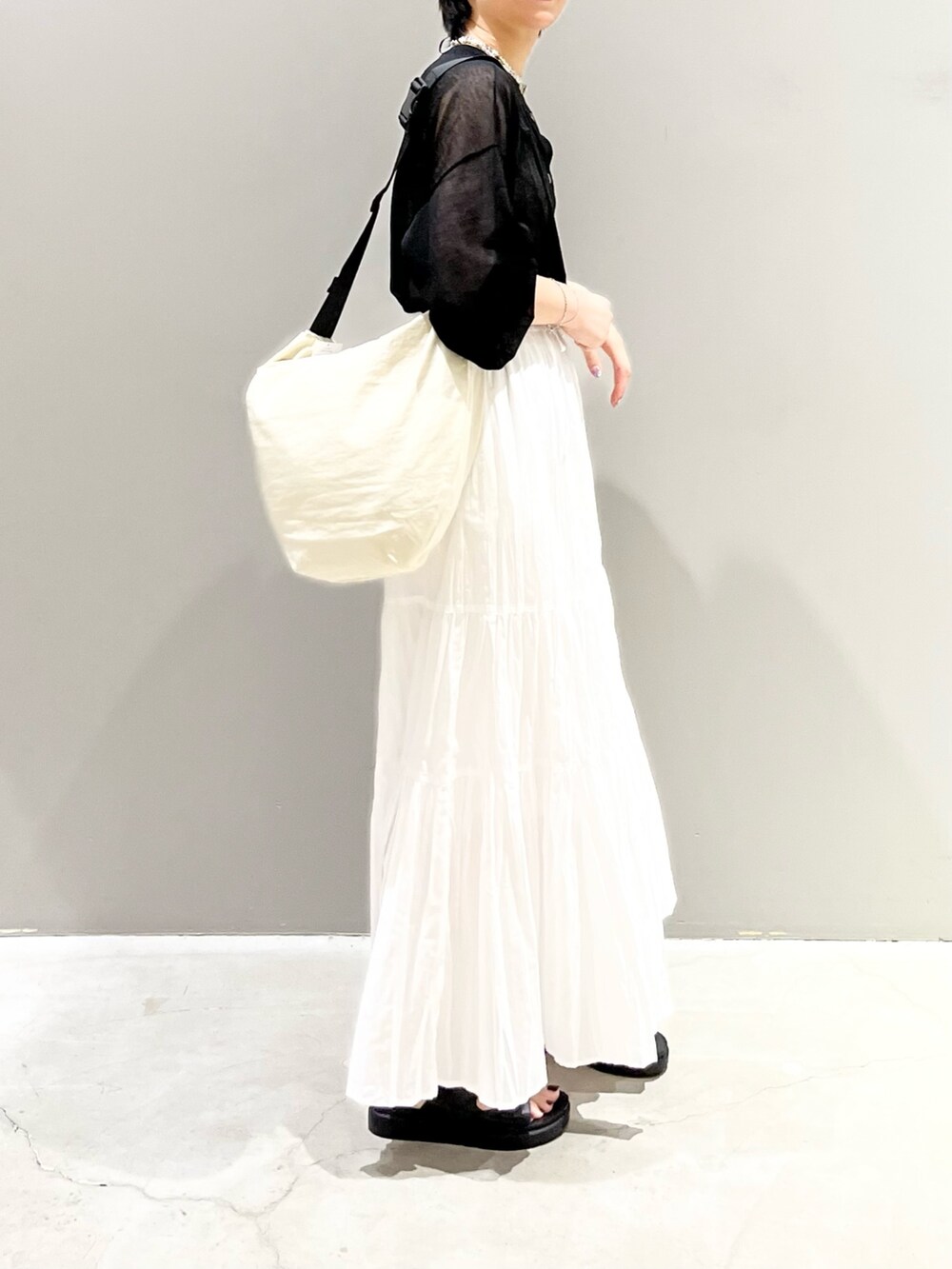 ブラック系のサンダル、ホワイト系のスカート、ホワイト系のショルダーバッグを着用したレディースの夏コーディネートの4枚目の写真