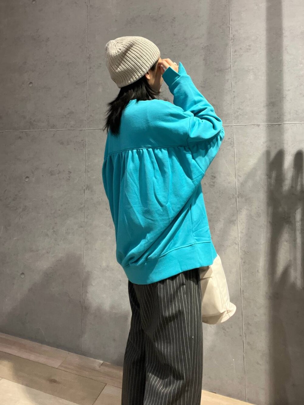 ホワイト系のショルダーバッグ、グレー系のその他パンツ、ブラック系のスニーカーを着用したレディースの冬コーディネートの6枚目の写真