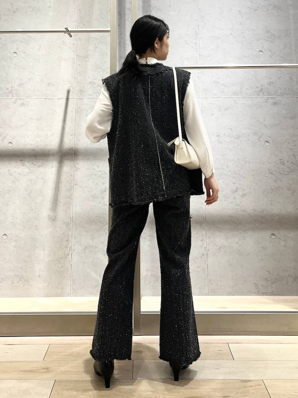 ホワイト系のシャツ/ブラウス、ブラック系のパンプス、ホワイト系のショルダーバッグを着用したレディースの冬コーディネートの4枚目の写真