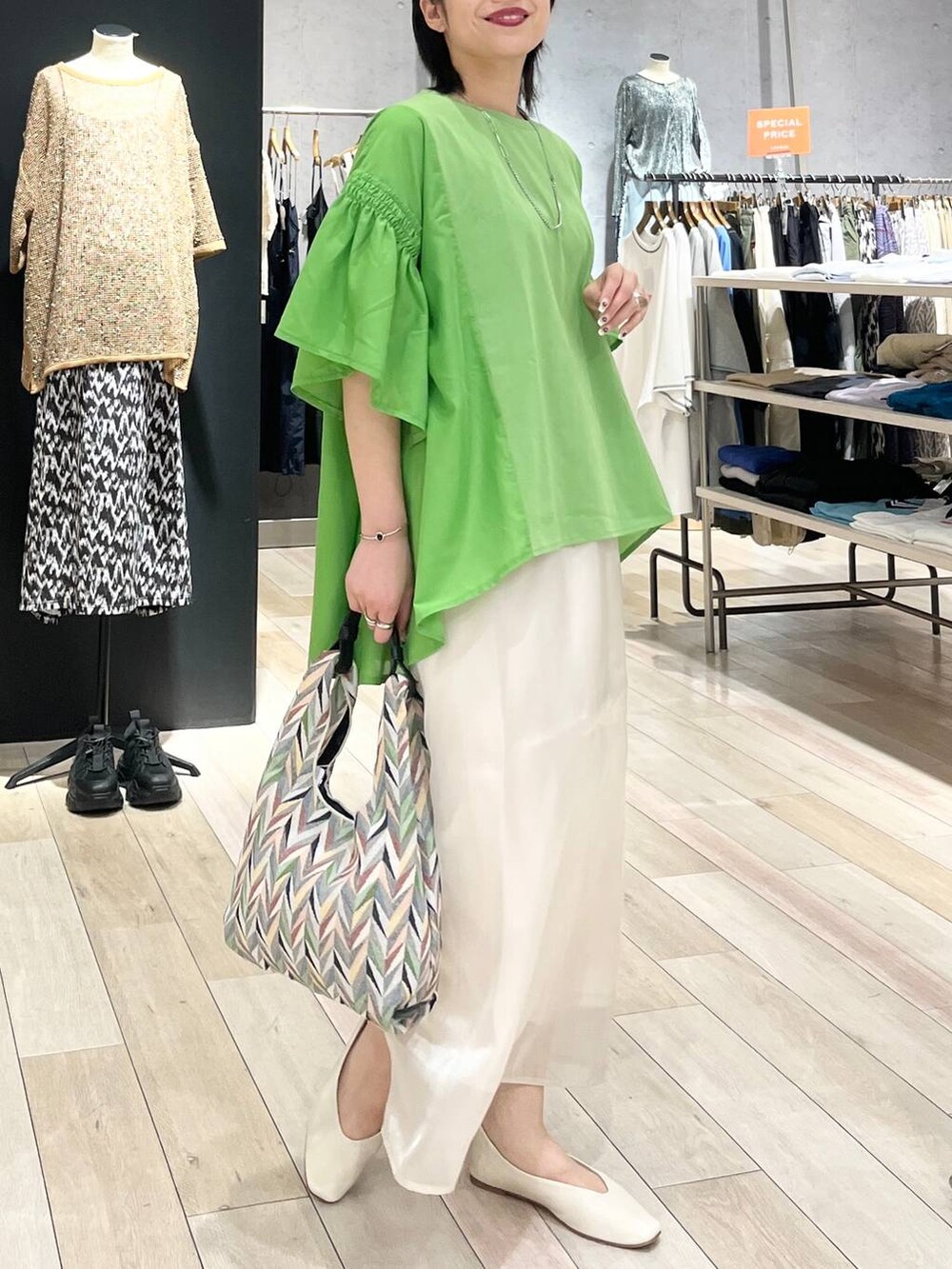 ホワイト系のハンドバッグ、ホワイト系のパンプス、ホワイト系のスカートを着用したレディースの春コーディネートの6枚目の写真