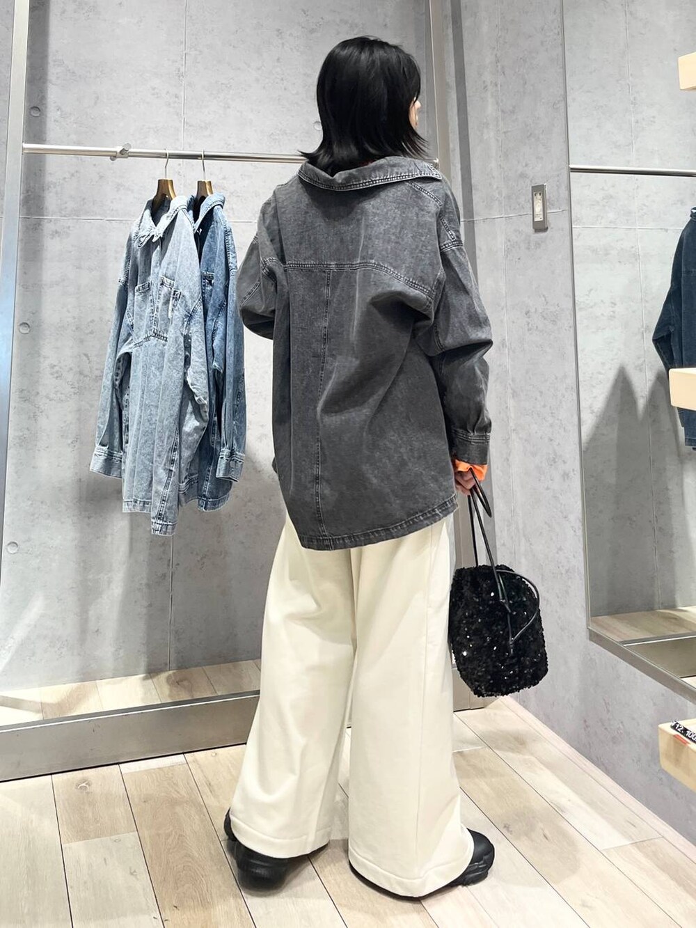 ブラック系のショルダーバッグ、ブラック系のスニーカー、ブルー系のシャツ/ブラウスを着用したレディースの冬コーディネートの3枚目の写真