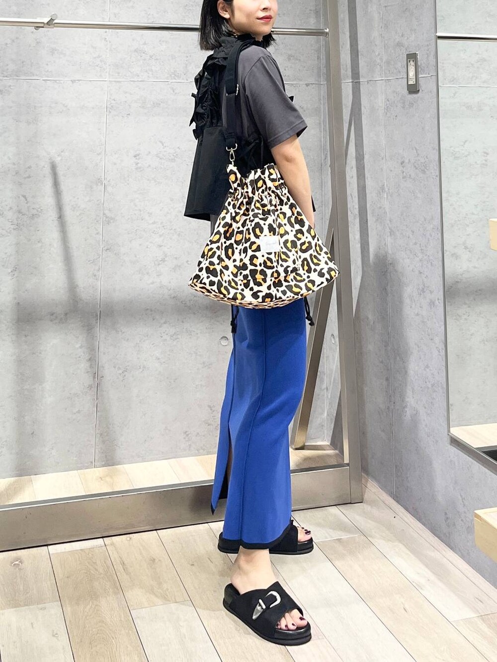 ブラック系のサンダル、ブラック系のベストを着用したレディースの夏コーディネートの3枚目の写真